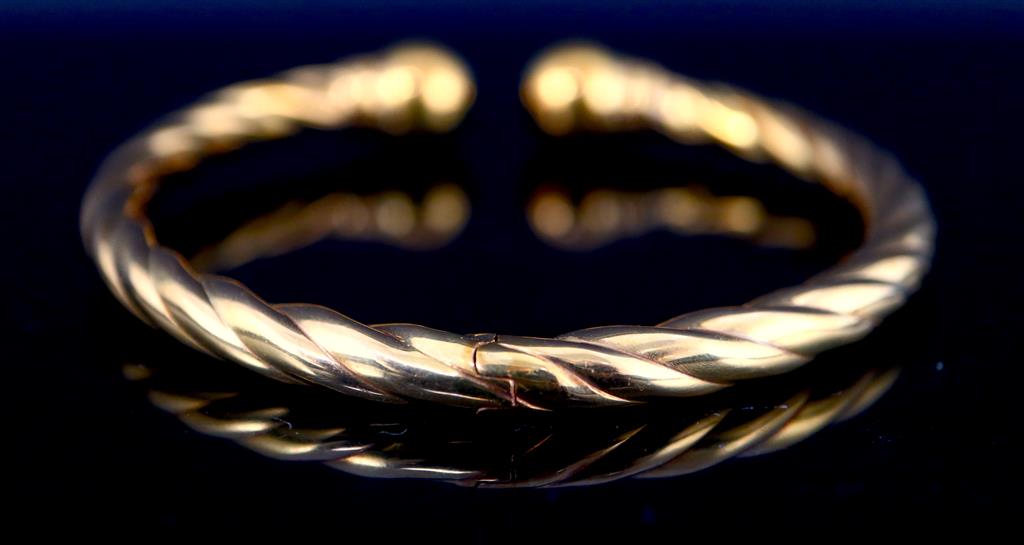 An Italian 18ct hollow gold twist sprung bangle,